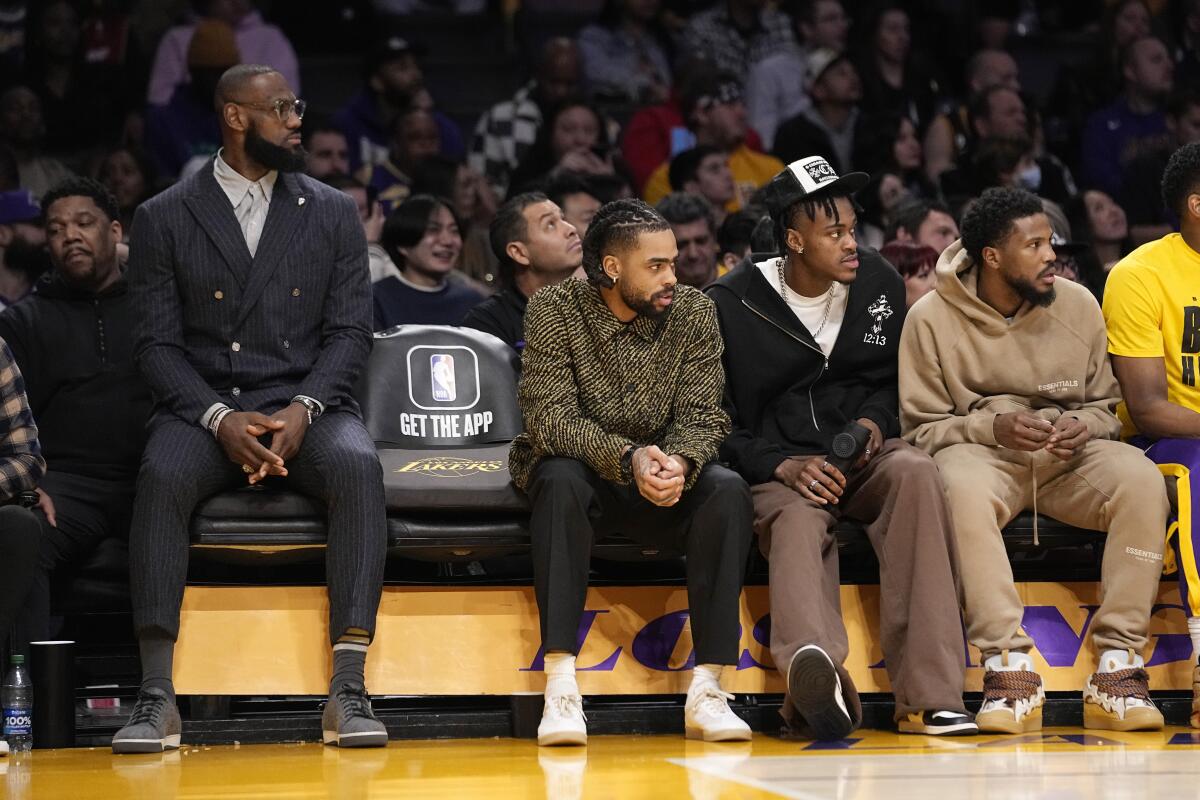 Lakers star LeBron James sits on the bench with the newly acquired D'Angelo Russell, Jarred Vanderbilt and Malik Beasley.