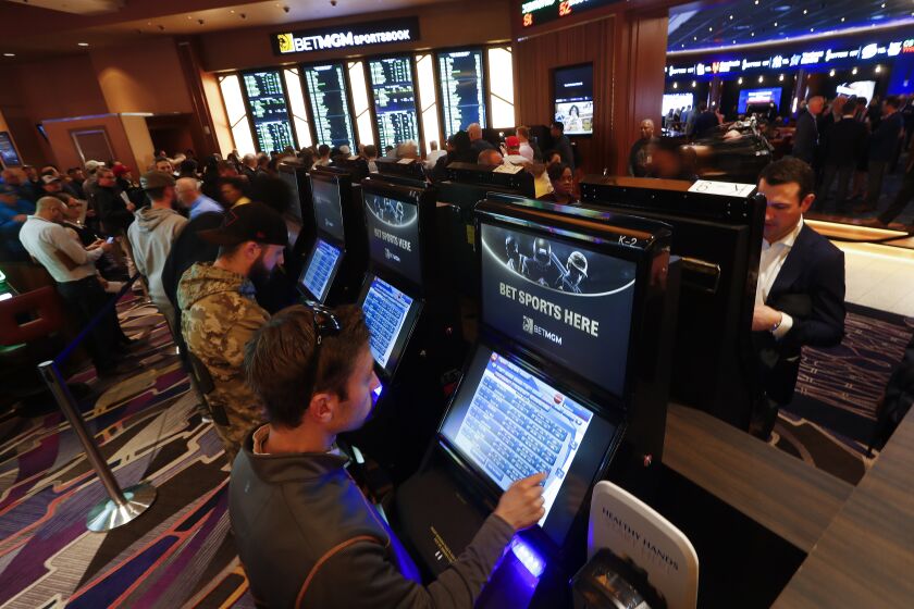 FILE - In this March 11, 2020, file photo, patrons place in person bets during the launch of legalized sports betting in Michigan at the MGM Grand Detroit casino in Detroit. Michigan casinos could launch online sports betting and gambling games in December once state lawmakers waive the remaining time they have to review proposed licensing rules. The Joint Committee on Administrative Rules, which has 10 legislators, will effectively bless the new regulations at a meeting Tuesday, Dec. 1, 2020, said the chairman, Republican Sen. Pete Lucido. (AP Photo/Paul Sancya File)