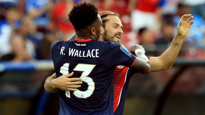 Rodney Wallace is congratulated by teammate Marco Urena after scoring against French Guiana during the second half Friday.