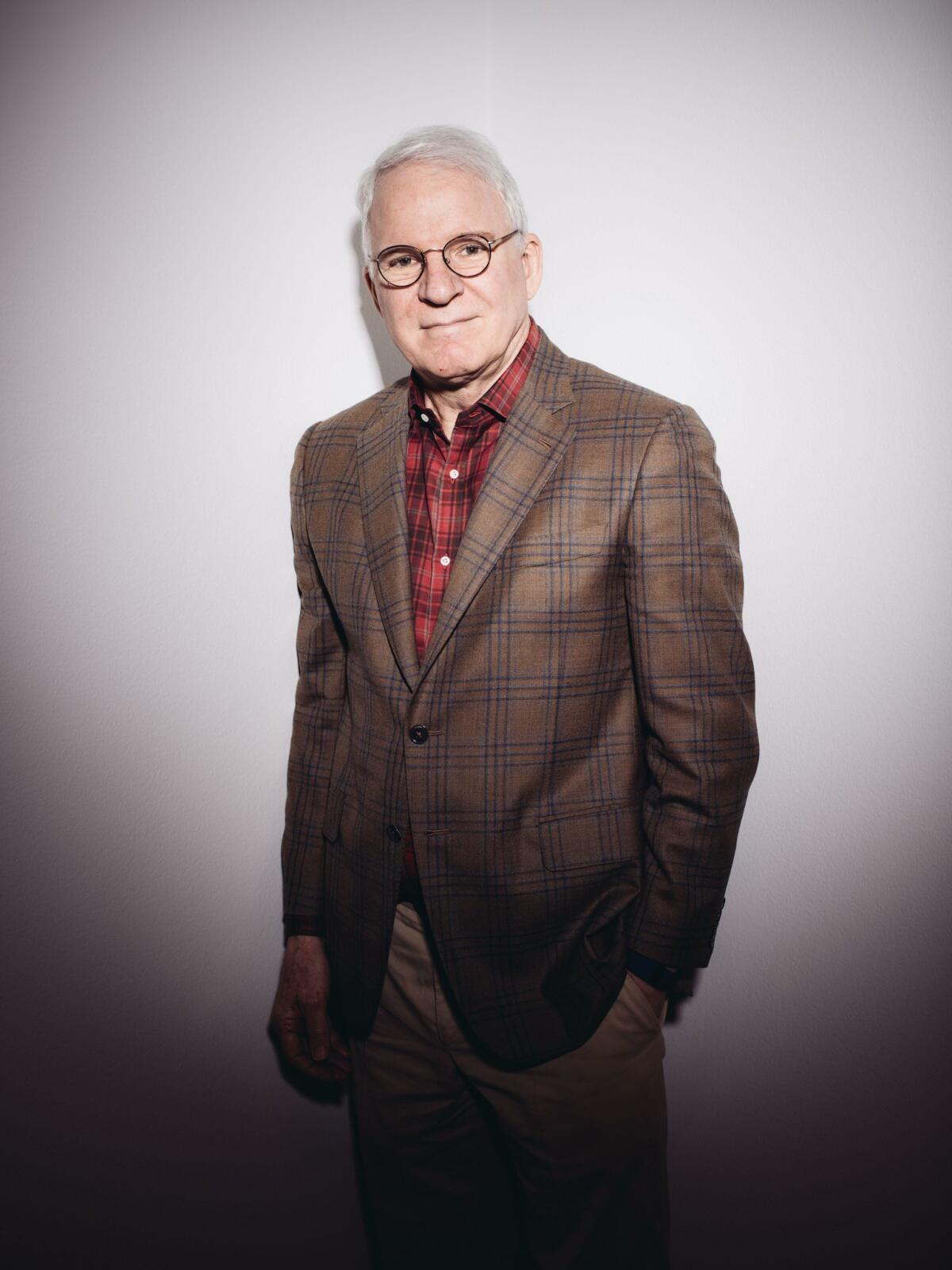 In this Wednesday, Oct. 7, 2015, photo, curator and actor-comedian Steve Martin poses for a portrait in a gallery for the exhibit "The Idea of North: The Paintings of Lawren Harris" at The Hammer Museum in Los Angeles. (Photo by Casey Curry/Invision/AP)