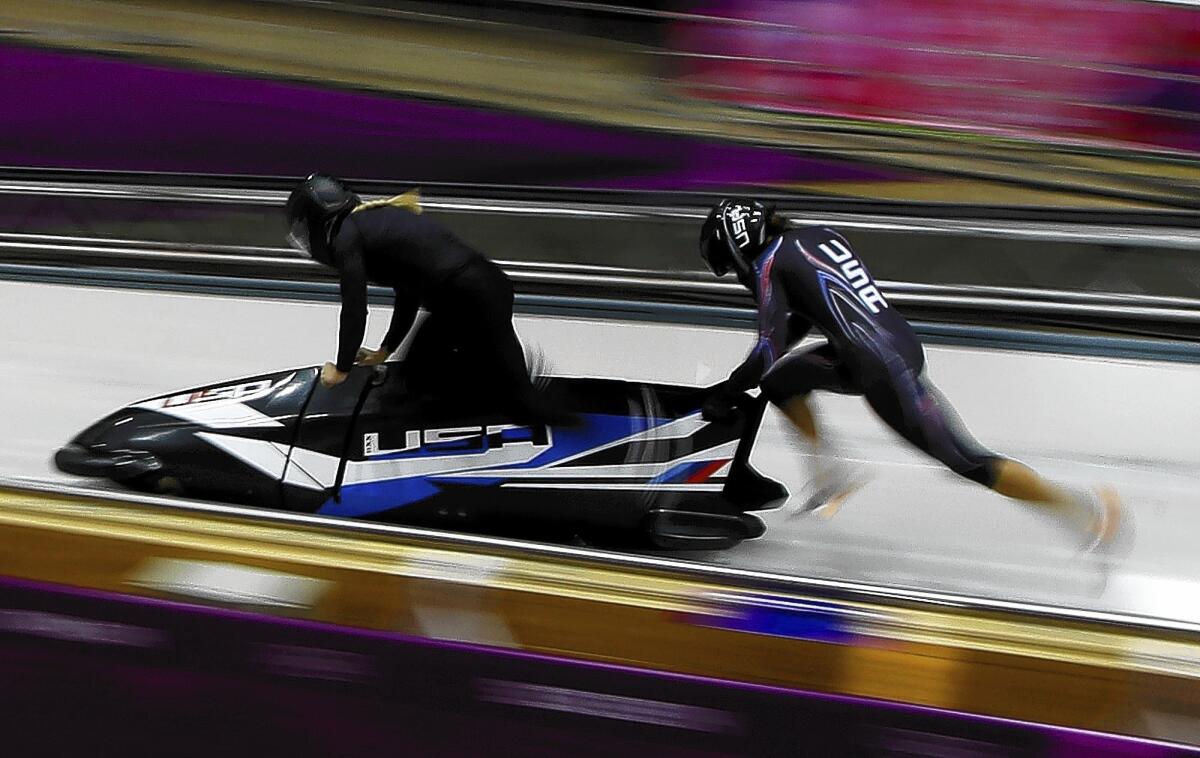 The USA-2 sled, piloted by Jamie Greubel, starts a run during a training session for the women's two-person bobsled at the 2014 Winter Olympics.