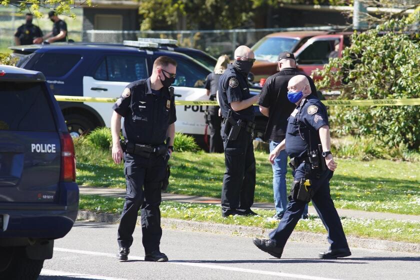 FILE - In this Friday, April 16, 2021, file photo, law enforcement personnel work at the scene following a police-involved shooting of a man at Lents Park, in Portland, Ore. Police fatally shot a man in the city park Friday, April 30, 2021 after responding to reports of a person with a gun. Unlike shootings involving police around the country there was no body camera footage of this encounter. Portland, which has become the epicenter of racial justice protests, is one of the few major U.S. cities where police do not have body cameras. (Beth Nakamura/The Oregonian via AP, File)