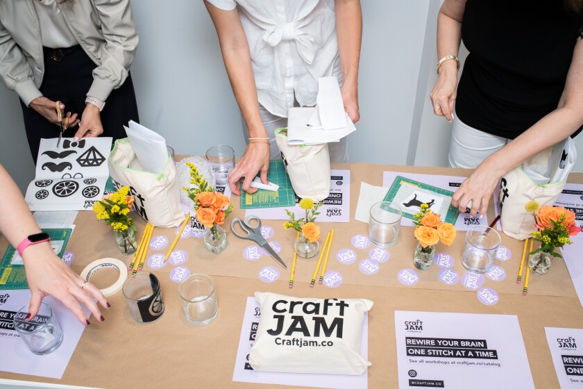 People stand around a table with craft activities.
