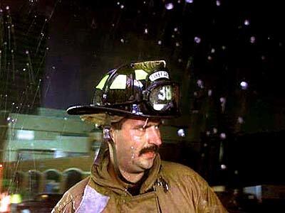 Rain pours on a firefighter as he takes a break.