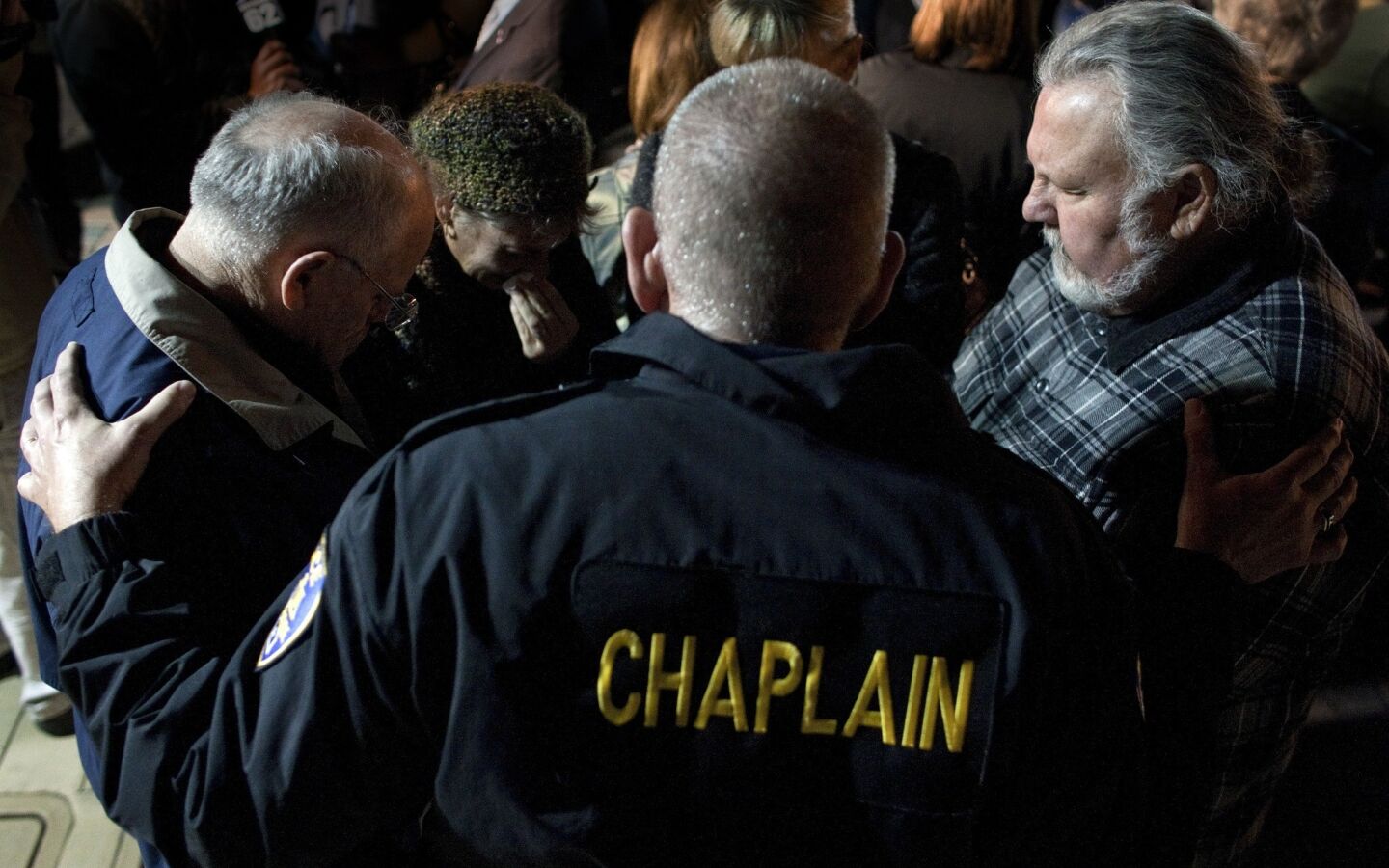 Riverside Police Chaplain Steve Ballinger comforts residents during a vigil at City Hall for the slain and wounded Riverside police officers.