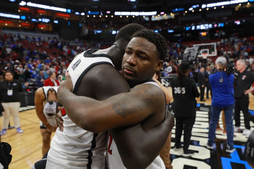 Louisville, KY - March 26: San Diego State's Aguek Arop, left, hugs Darrion Trammell after he made the game-winning free throw as the Aztecs celebrated a 57-56 victory over Creighton n an Elite 8 game in the NCAA Tournament on Sunday, March 26, 2023 in Louisville, KY. (K.C. Alfred / The San Diego Union-Tribune)