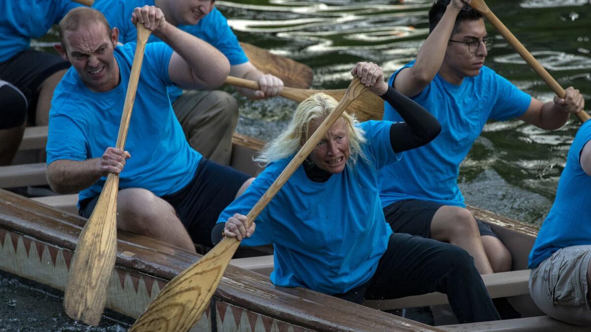 Lisa Jacobs, 55, and her teammates reach the finish line in the semifinals of the annual canoe race this month at the Rivers of America attraction at Disneyland.