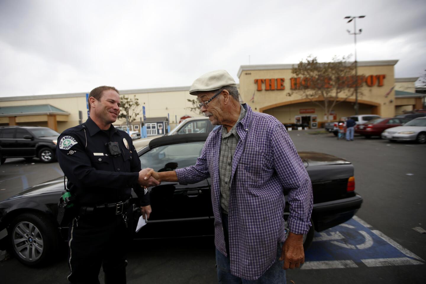 L.A. police Officer Ben Yasnyi, left, greets E. Lagemann, 80, after checking the motorist's disabled placard in a parking lot in South Los Angeles.