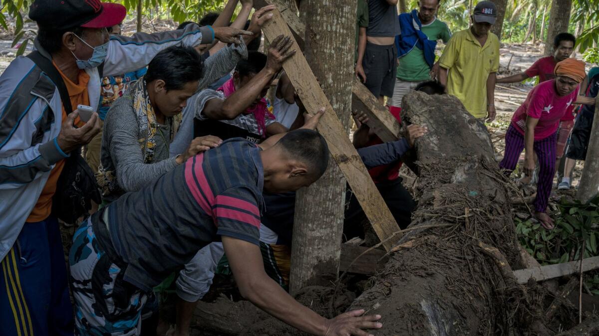 Family and friends recover the body of Amir Ampaso, 60, who was killed in Typhoon Tembin on Christmas Day in the Philippines.