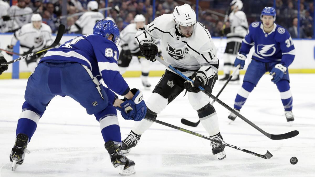 Tampa Bay Lightning defenseman Erik Cernak, left, knocks the puck away from Kings center Anze Kopitar during the first period of Monday's game.