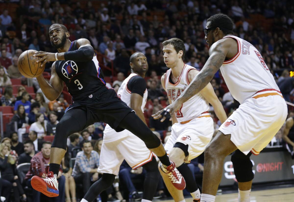 Clippers point guard Chris Paul (3) drives to the basket past Heat guard Goran Dragic (7) and forward Amare Stoudemire during the first half Sunday in Miami.