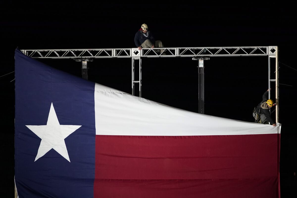 Workers remove a Texas flag after a primary election night event for Texas Gov. Greg Abbott, Tuesday, March 1, 2022, in Corpus Christi, Texas. (AP Photo/Eric Gay)