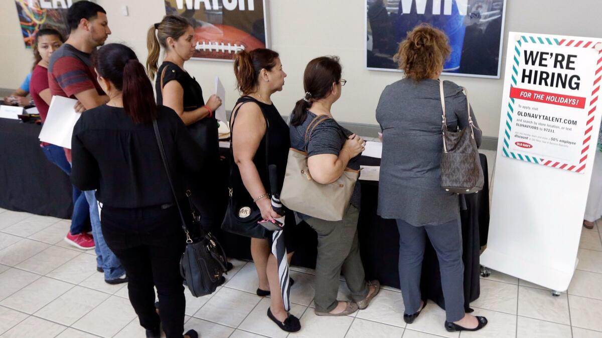 People wait in line at a job fair in Florida. The level of unemployment benefits has been below 300,000 for more than two years, a stretch not equaled in more than four decades.
