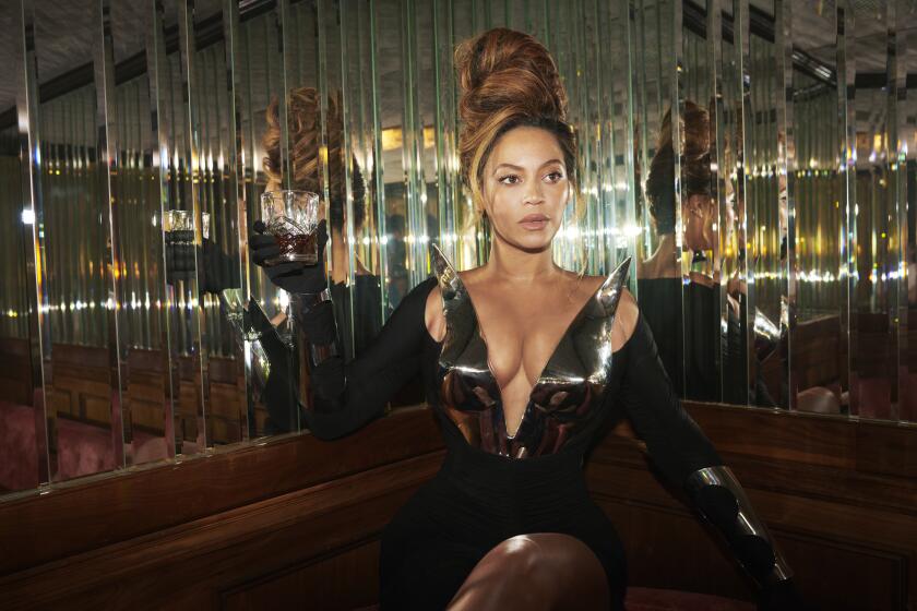 Beyonce in a deep-neck dress sitting in a reflective room