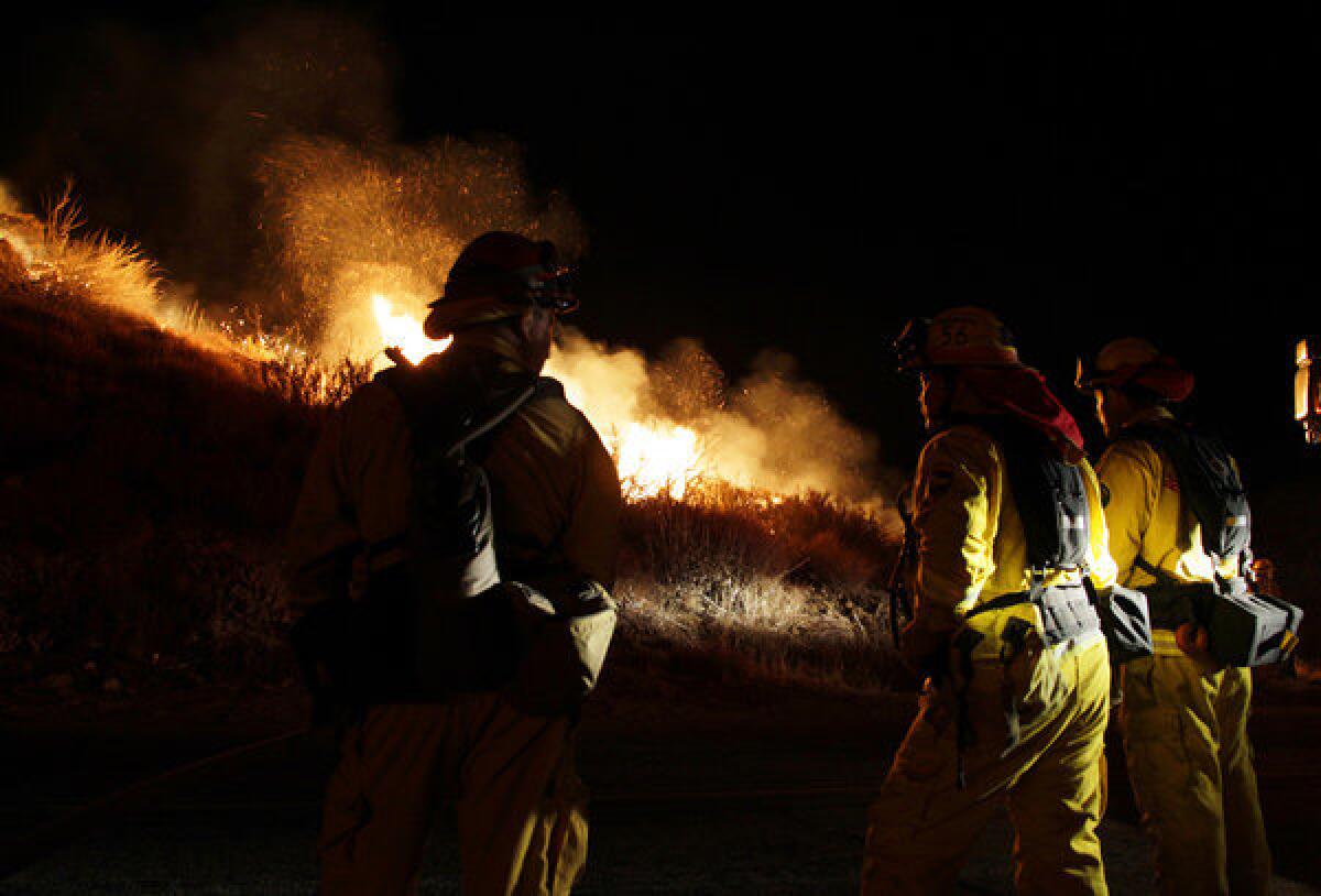 Firefighters take a stand in Twin Pines as the Silver Fire makes a push towards the road late in the evening.