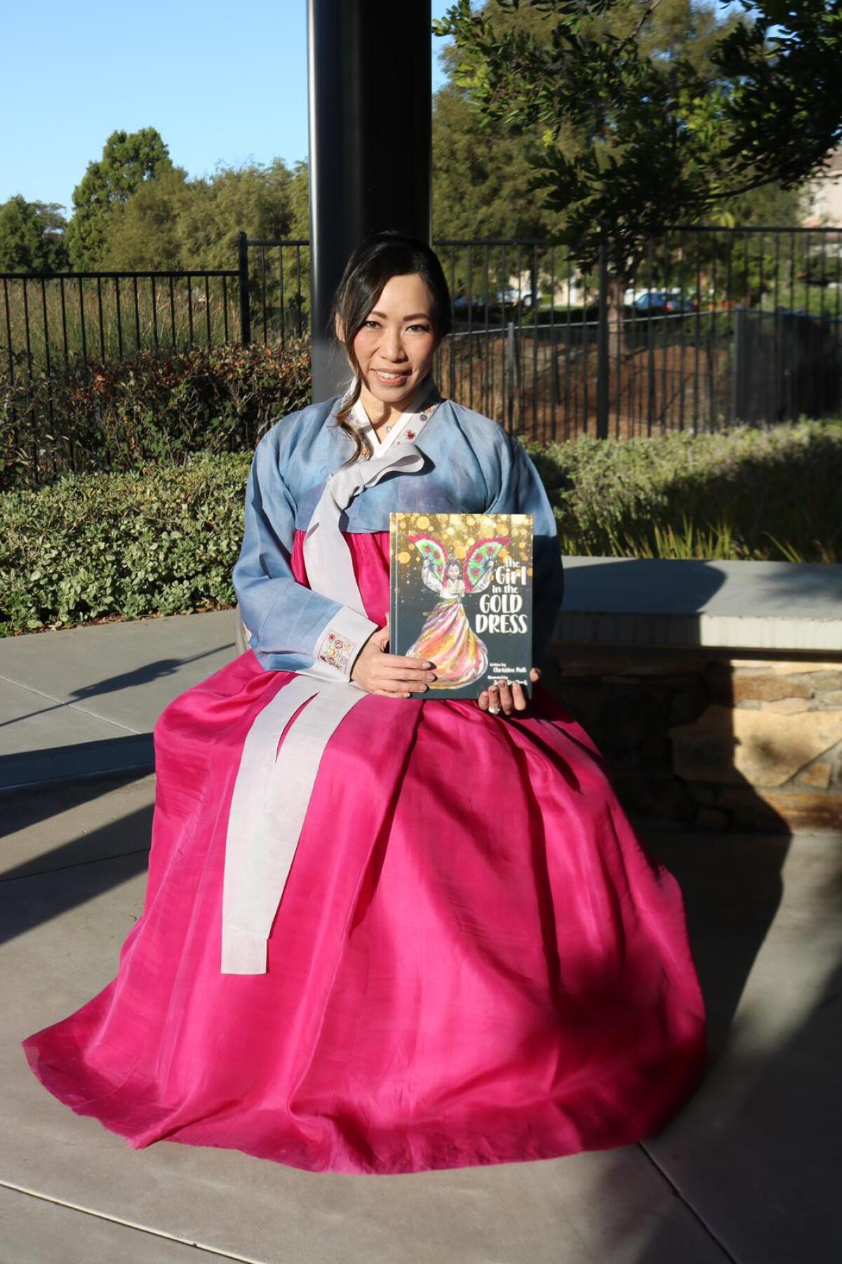 Author Christine Paik wears a hanbok like the character in "The Girl in the Gold Dress."