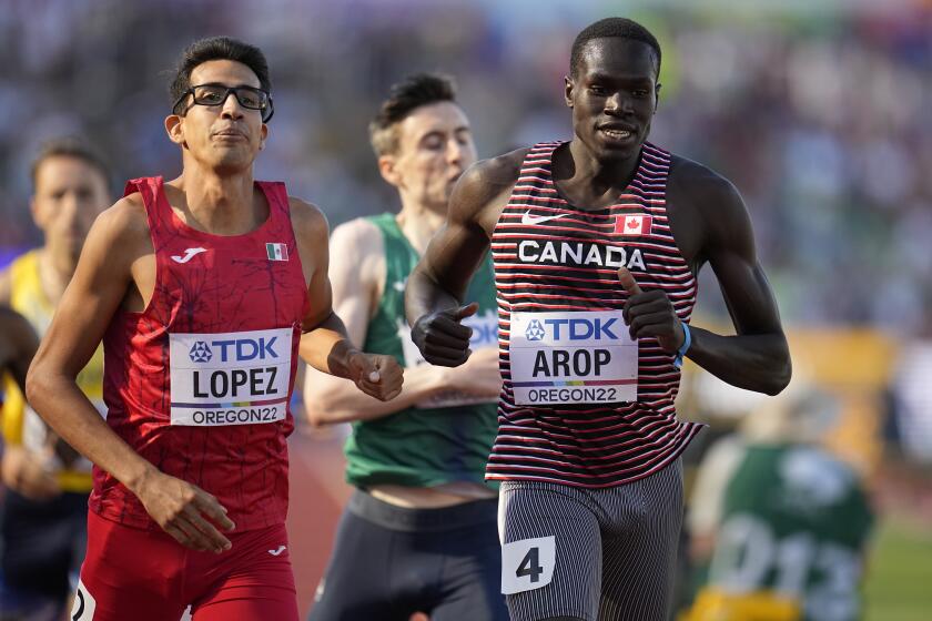El canadiense Marco Arop y el mexicano Tonatiú López finalizan la eliminatoria de los 800 metros en el Mundial de atletismo, el miércoles 20 de julio de 2022, en Eugene, Oregon (AP Foto/Ashley Landis)
