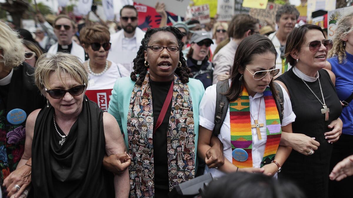 Clergy members and others lock arms in solidarity during a protest against U.S. immigration policies that drew hundreds of people to Brownsville, Texas, on Thursday.