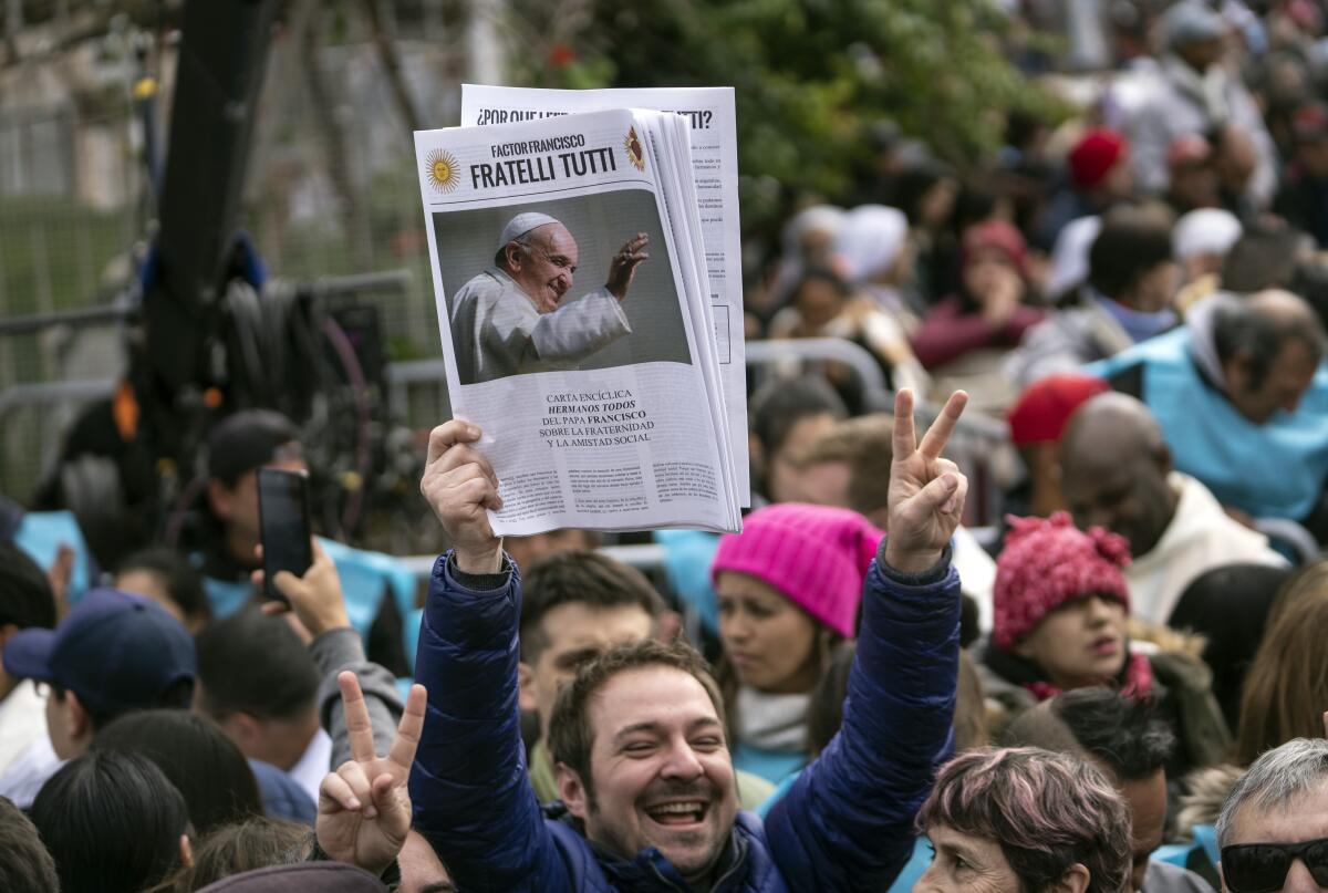 Un hombre sostiene una foto del papa Francisco antes de una misa católica 