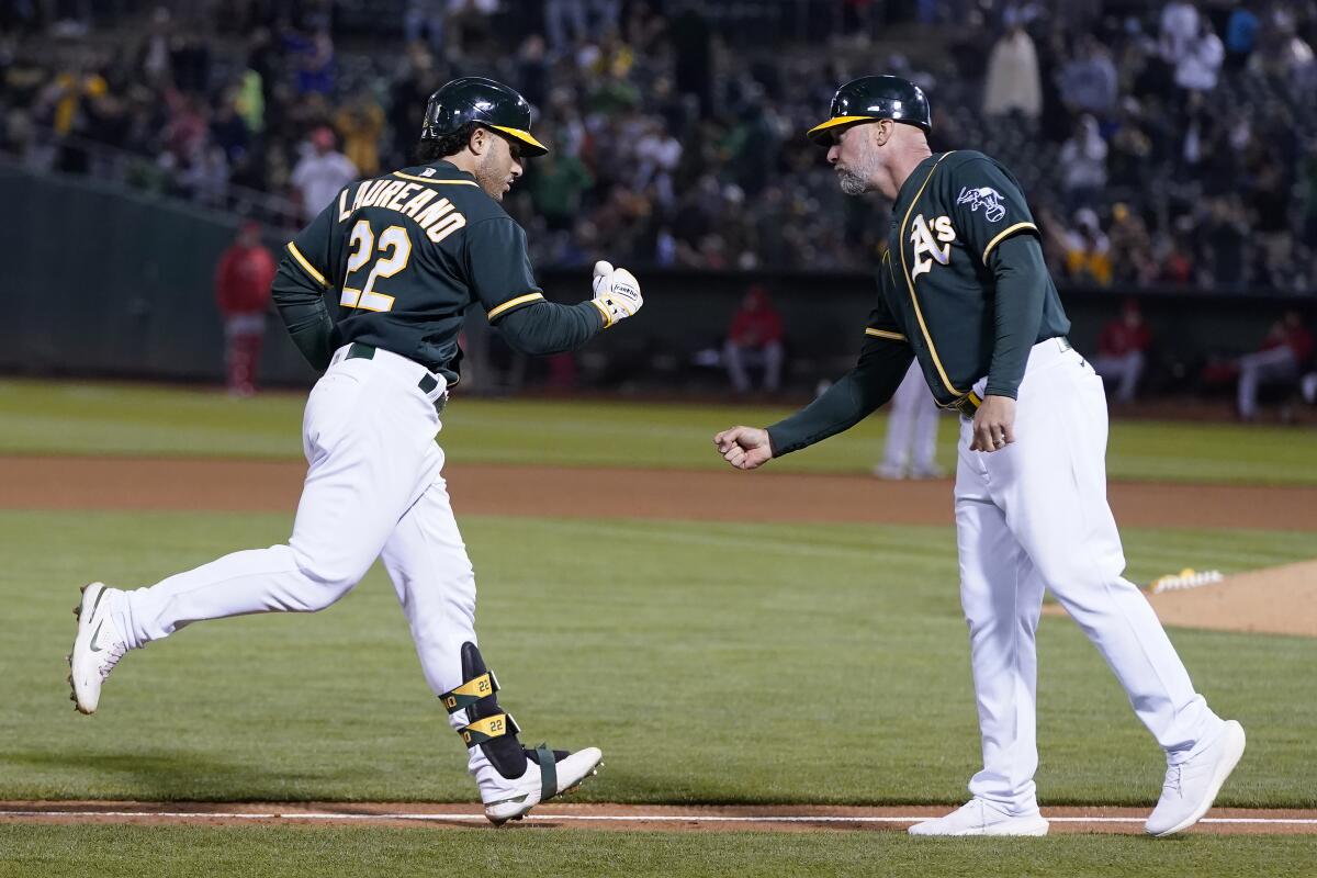 Oakland Athletics' Ramon Laureano, left, is congratulated by third base coach Mark Kotsay after hitting a three-run home run against the Los Angeles Angels during the seventh inning of a baseball game in Oakland, Calif., Monday, July 19, 2021. (AP Photo/Jeff Chiu)