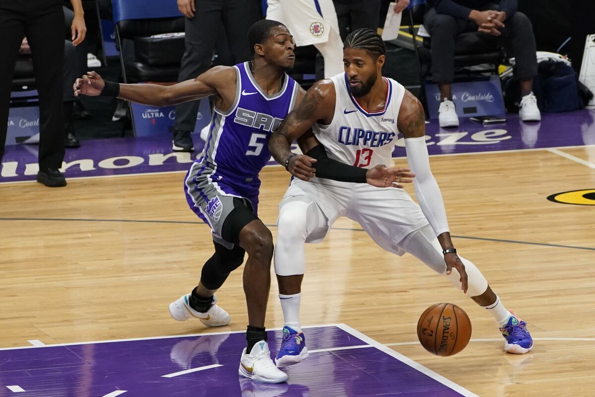 The Clippers' Paul George drives against the Kings' De'Aaron Fox during the first quarter Jan. 15, 2021.