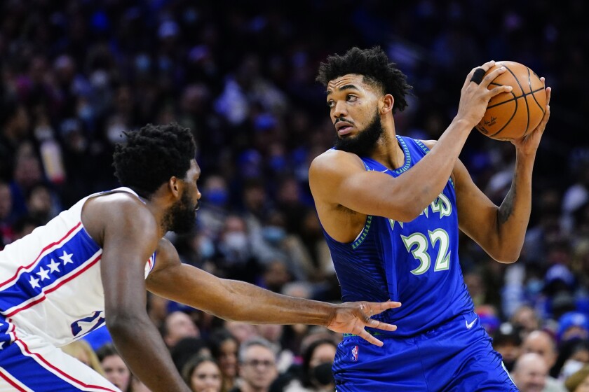 Minnesota Timberwolves' Karl-Anthony Towns, right, tries to get past Philadelphia 76ers' Joel Embiid during the first half of an NBA basketball game, Saturday, Nov. 27, 2021, in Philadelphia. (AP Photo/Matt Slocum)