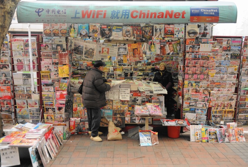 A newspaper vendor in Shanghai in 2013. Chinese authorities have been confiscating any printed material they deem objectionable from people departing the mainland.