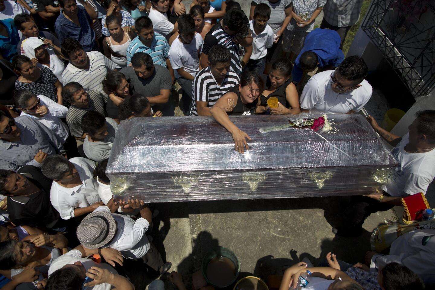 Relatives cry over the coffin of Kexly Valentino who died with her mother Gabriela and her brother Alex in the earthquake, in Montecristi, Ecuador, Tuesday, April 19, 2016.