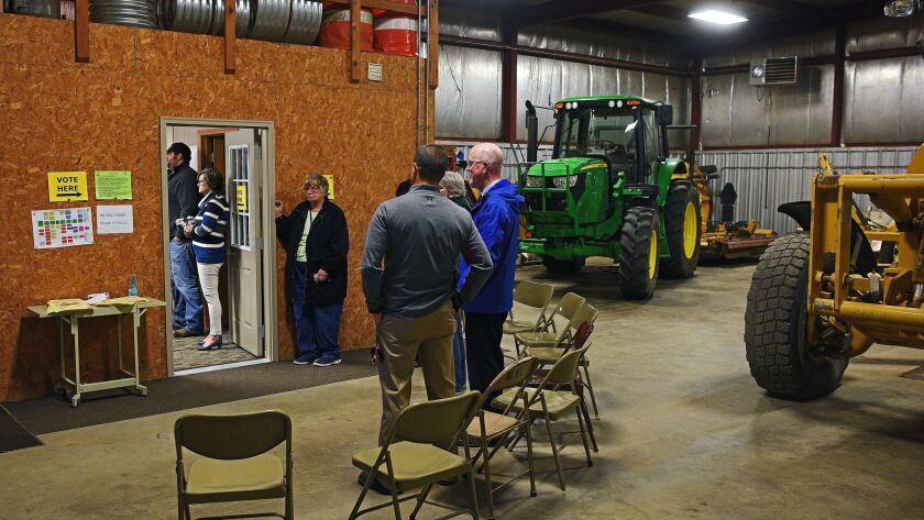Voters wait in line to cast their ballots in the Wall Lake Township building, west of Sioux Falls, S.D., on Nov. 8.