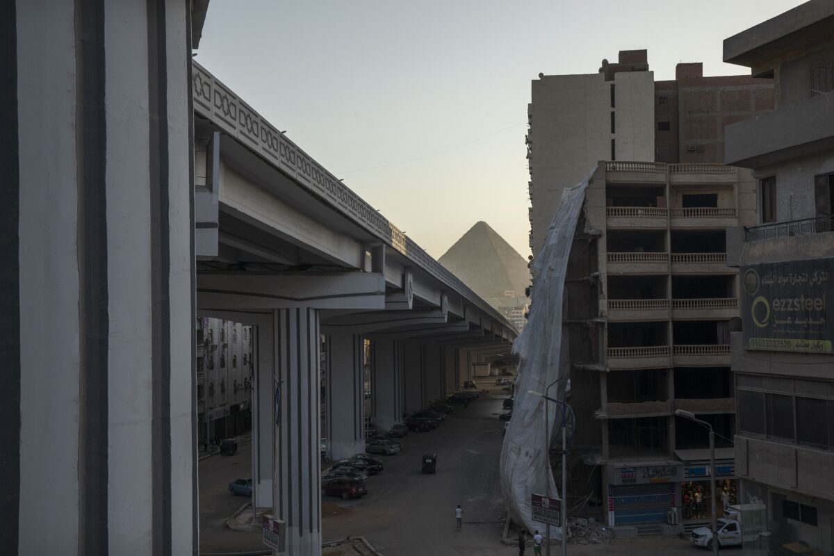FILE - A bridge under construction is part of mega projects that include building new cities, roads, bridges and tunnels as the government tries to ease traffic on congested roads in one of the world's most crowded cities, in the Giza suburb of Cairo, Egypt, July 19, 2021. The massive road construction projects have erased some of the oldest remaining green spaces in Egypt’s capital. (AP Photo/Nariman El-Mofty, File)