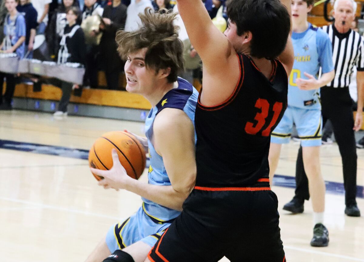 Marina High's Ryan O'Rouke (14) posts up against Huntington Beach's Bryce Via (31) during Friday night's game.