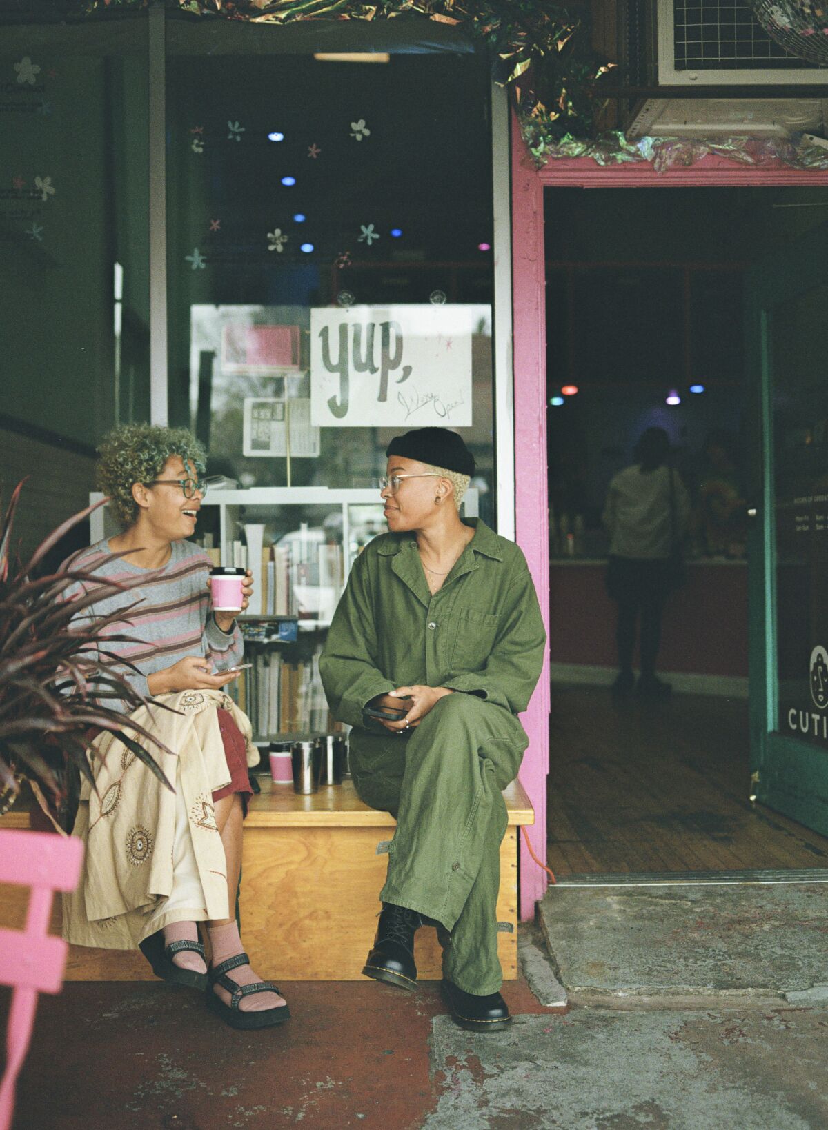 Two people sit outside Cuties Coffee in East Hollywood. The shop permanently closed during the pandemic.