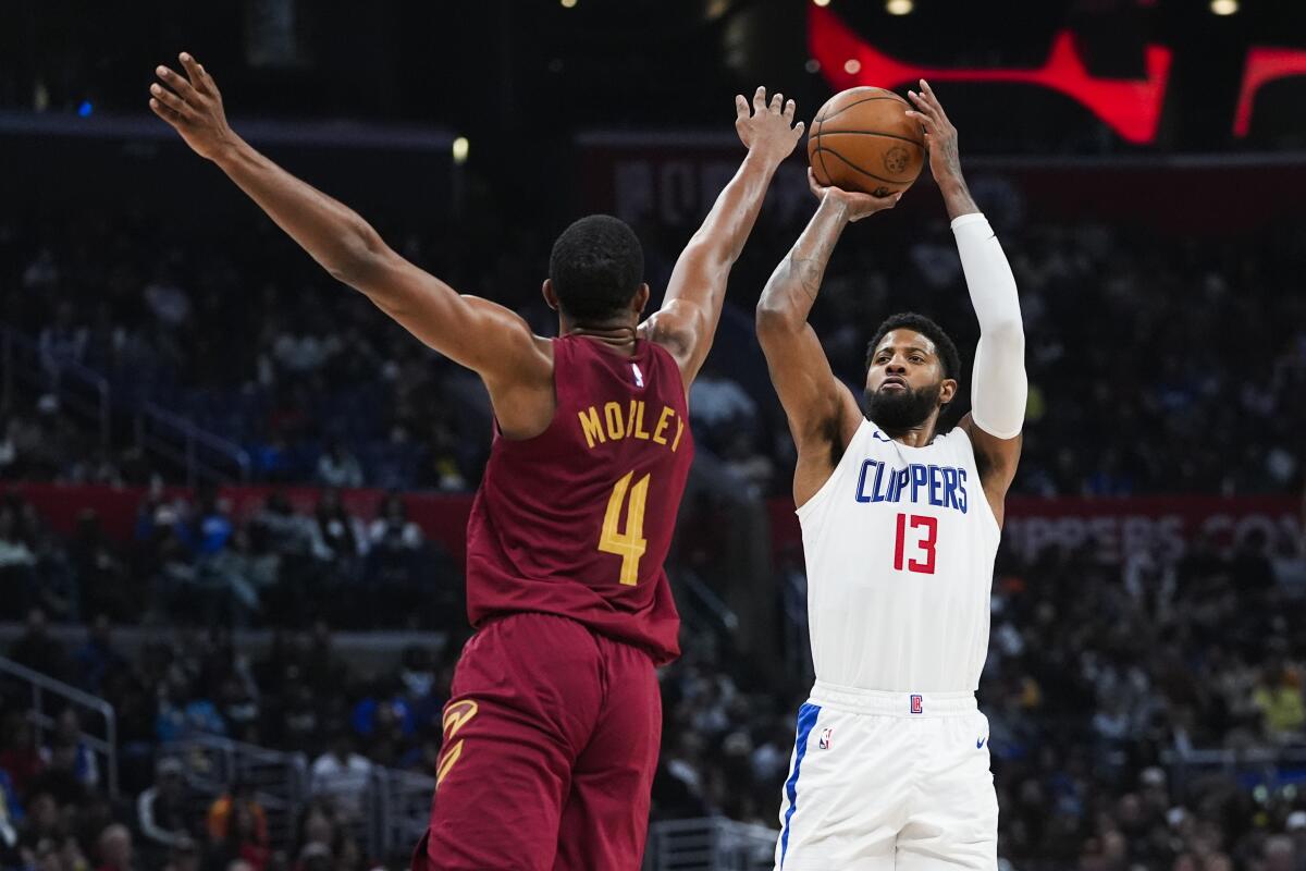 Clippers forward Paul George, right, shoots over Cavaliers forward Evan Mobley.