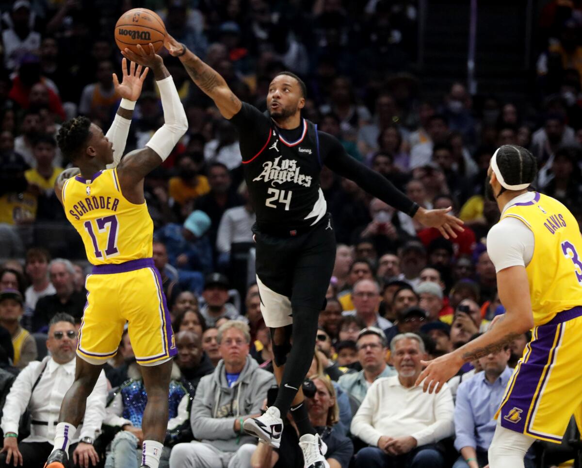 Clippers guard Norman Powell blocks a shot by Lakers guard Dennis Schroder in the first quarter at Crypto.com Arena.