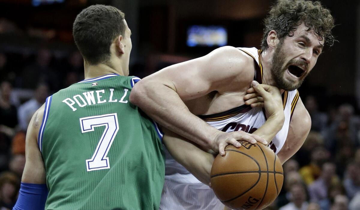 Cavaliers forward Kevin Love is fouled by Mavericks forward Dwight Powell during a game Thursday.
