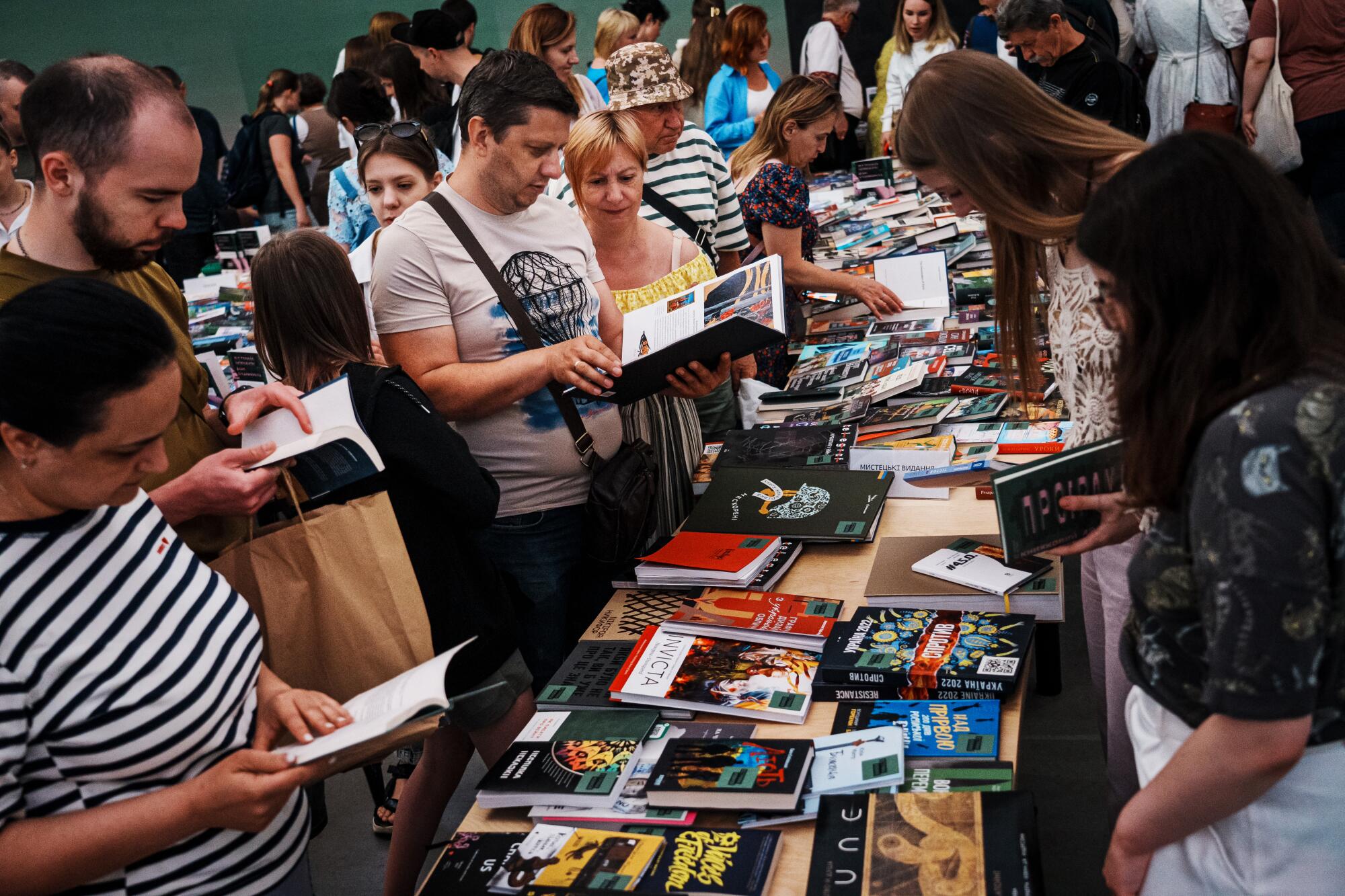 People look at books arrayed on a table  