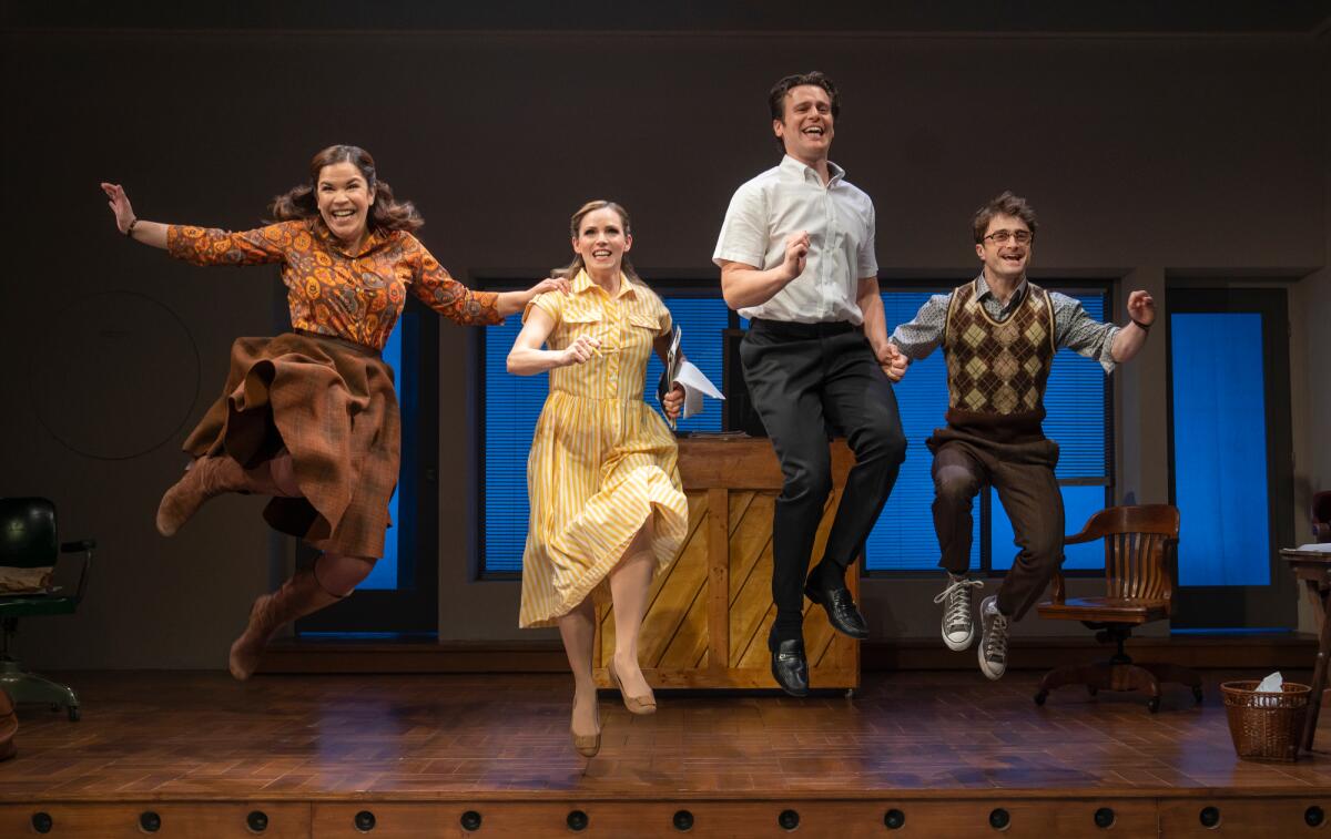 Four actors onstage leap joyfully into the air 