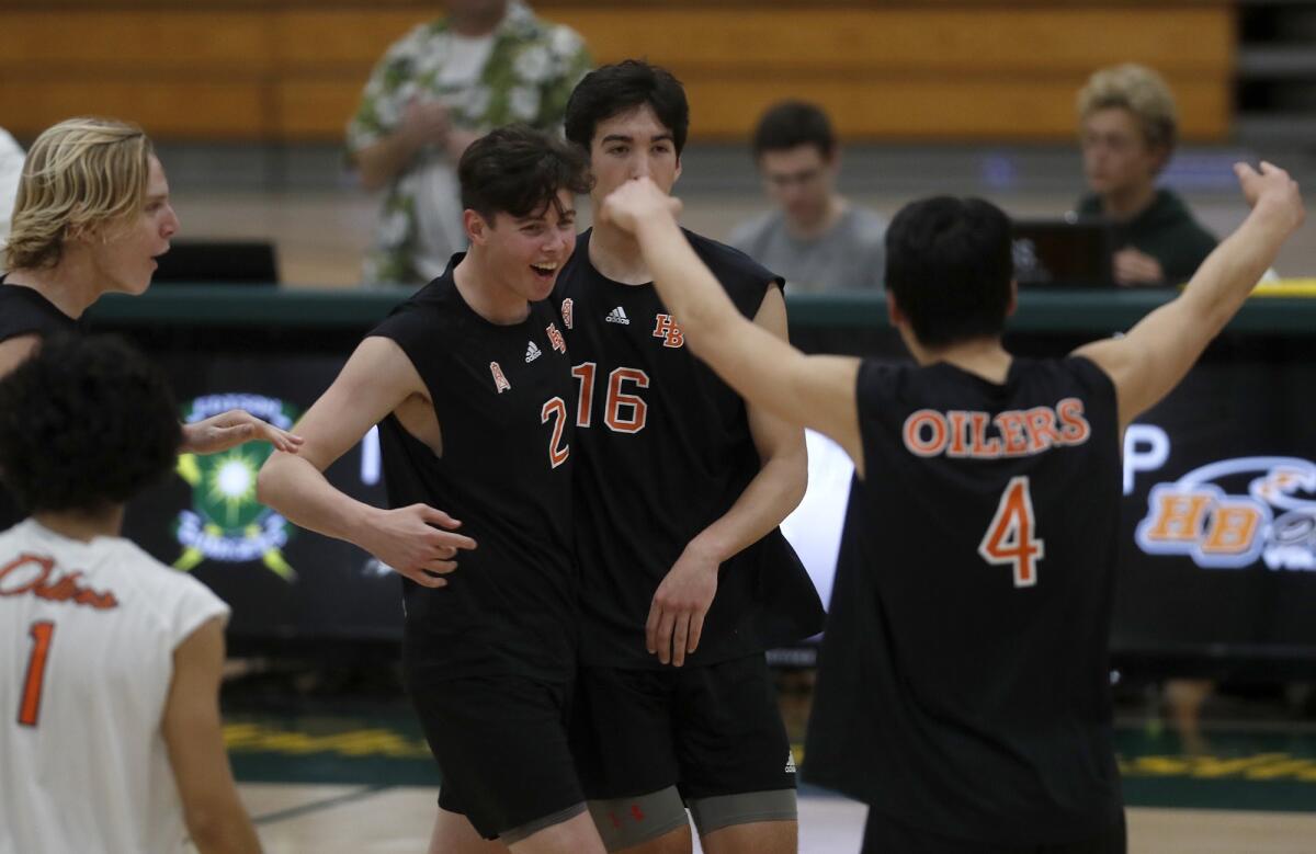 Huntington Beach High's Cayman LaFontaine (2) celebrates a point with teammates during the fourth set of a Sunset Conference crossover match on Wednesday.