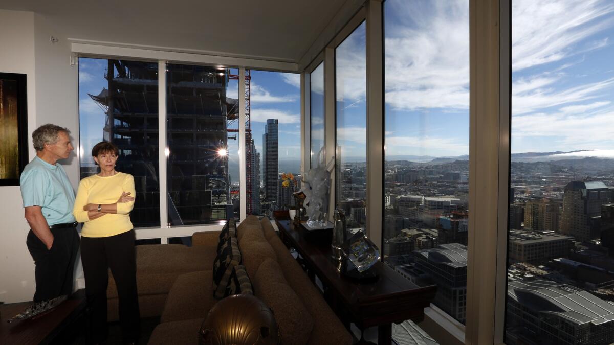 Jerry and Pat Dodson stand in the living room of their apartment in the Millennium Tower.