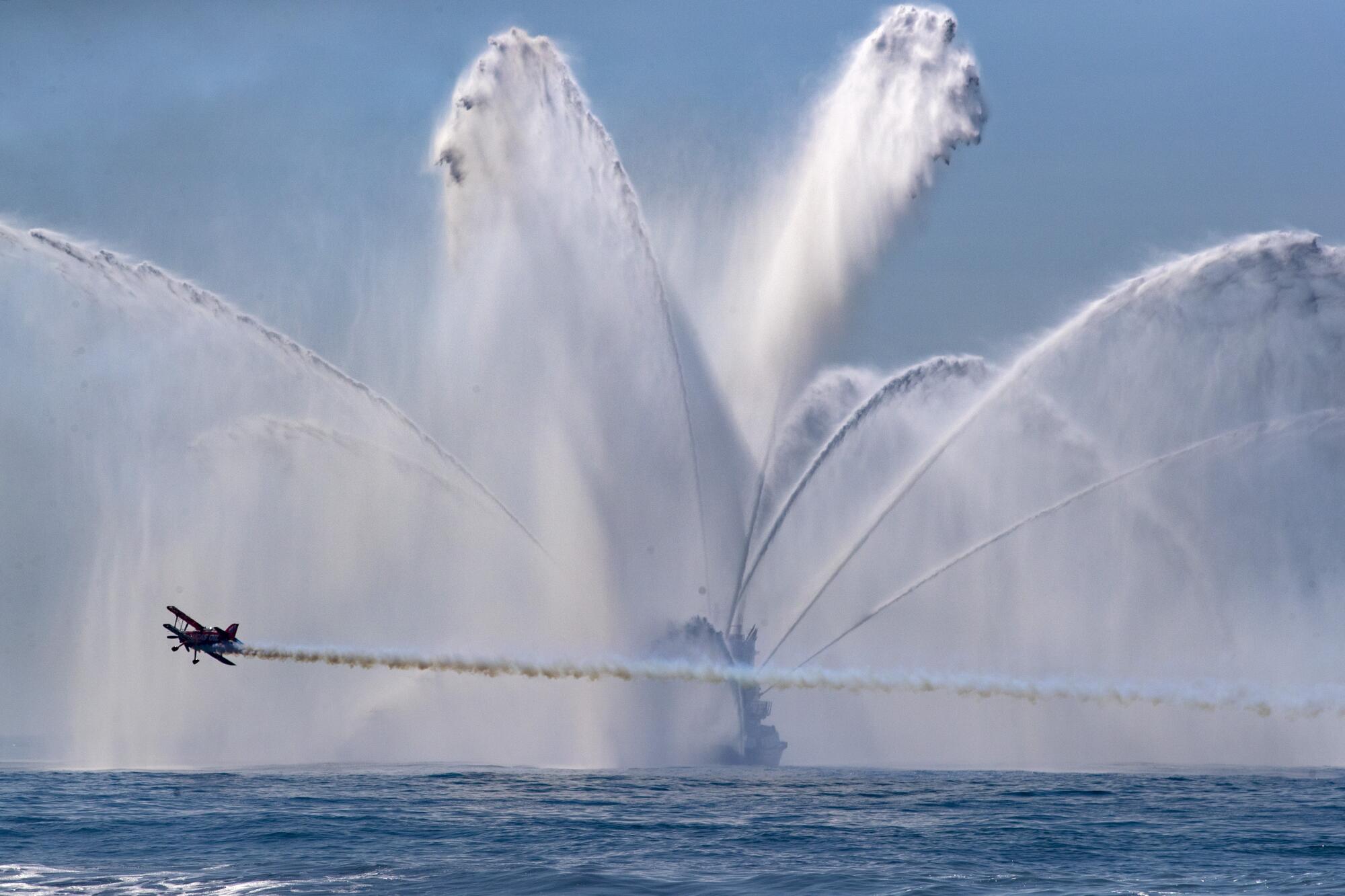 Michael Wiskus flies his biplane past an Orange County fire boat 