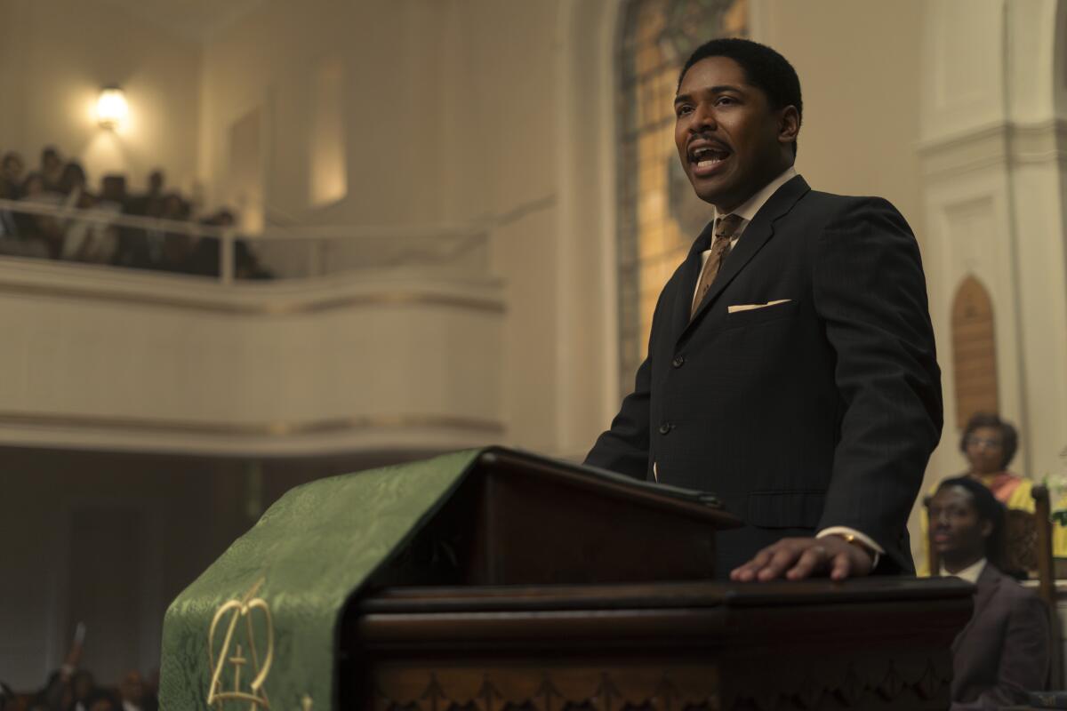 A man in a suite on the pulpit of a church.