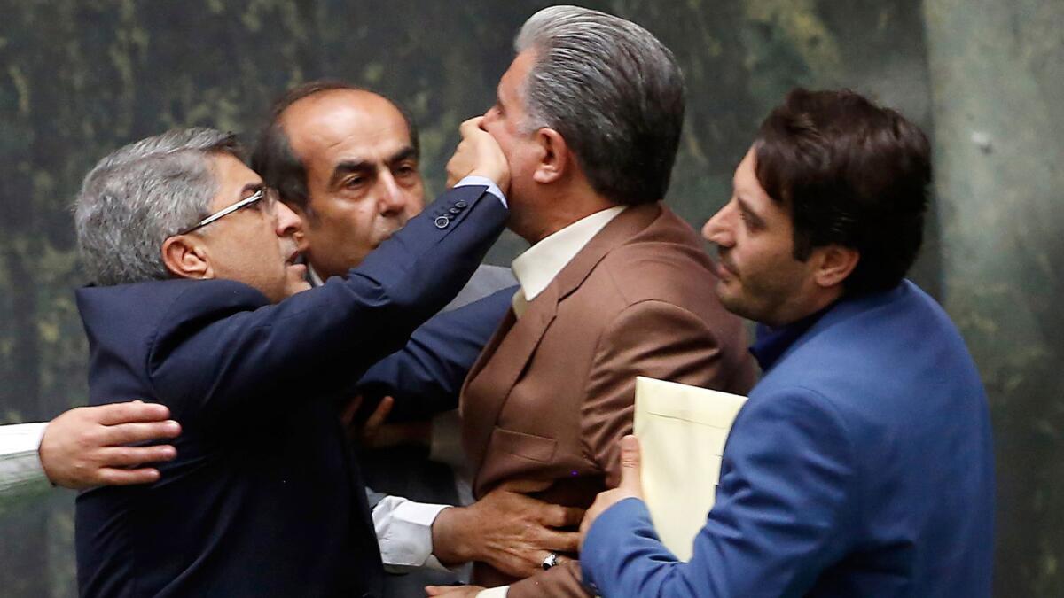 Iranian lawmakers argue over whether to oust the finance minister during a parliamentary session in Tehran on Aug. 28, 2018.
