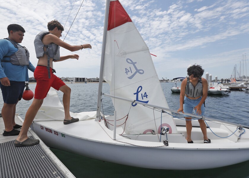 Juan Sanchez, Isaac Romo and Spencer Lopez, from left, prepare to set sail in a Lido 14.
