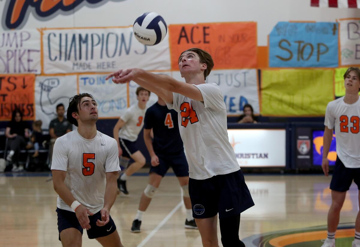 Pacifica Christian's Danny Dillon, center, keeps the ball in play during the second set against Xavier Prep.