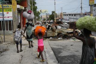 Residentes caminan por un camino bloqueado al evacuar el vecindario Delmas 22 para huir de la violencia de las pandillas en Puerto Príncipe, Haití, el jueves 2 de mayo de 2024. (AP Foto/Ramon Espinosa)