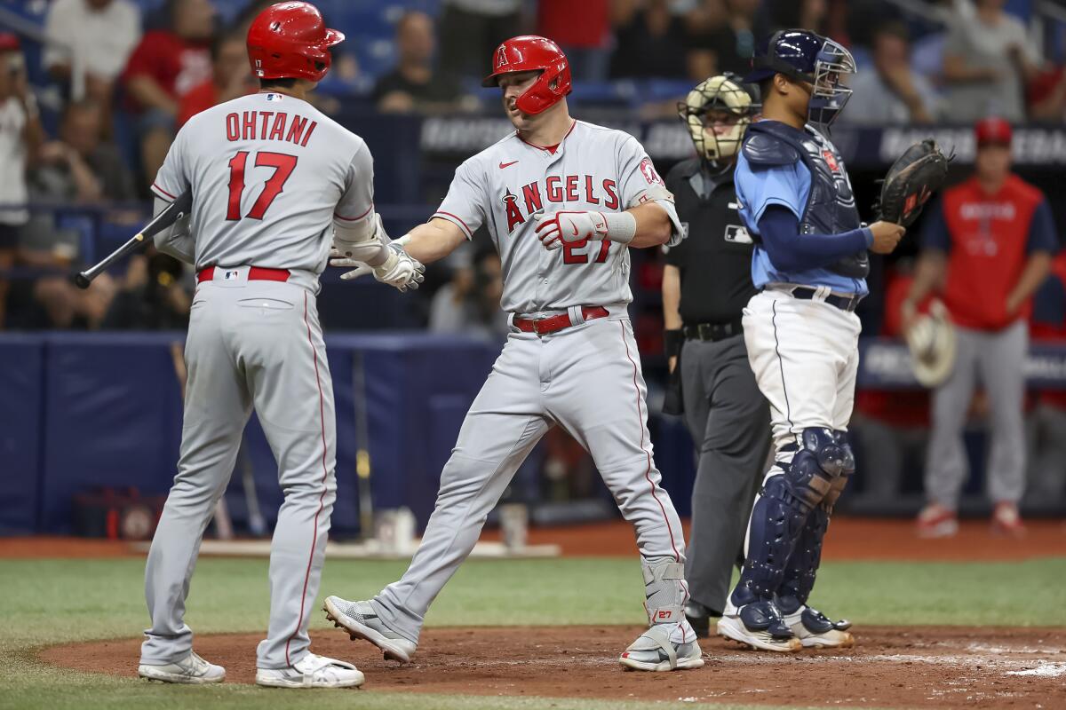 Shohei Ohtani congratulates Mike Trout after Trout's home run for the Angels against the Tampa Bay Rays on Aug. 23, 2022.