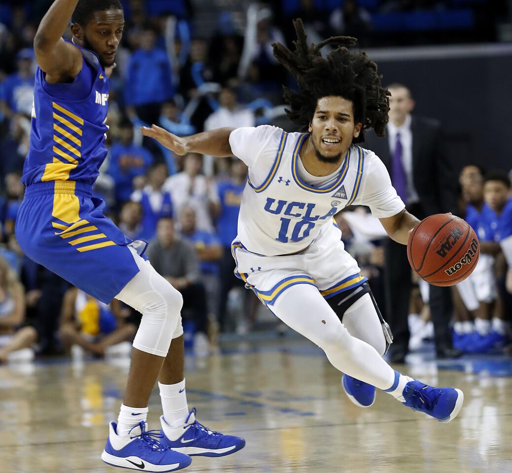 UCLA guard Tyger Campbell brings the ball up the court.