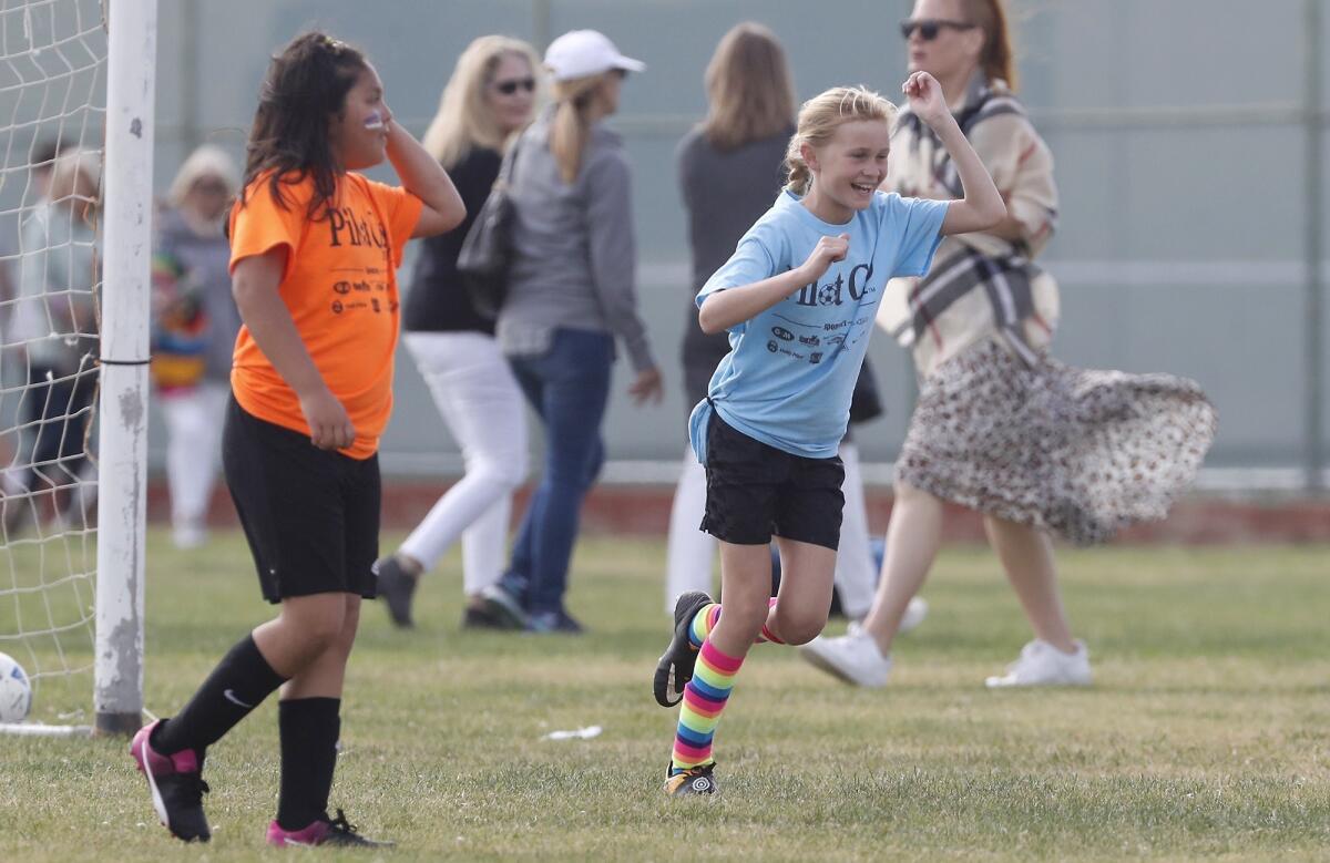 St. Joachim Catholic School's Madi Willard, right, cheers after scoring her team's first goal against Wilson in a girls’ third- and fourth-grade Bronze Division pool-play match at the Daily Pilot Cup on Friday at Costa Mesa High.