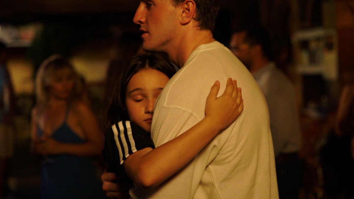 A girl hugs her father in a scene from the film "After sun."