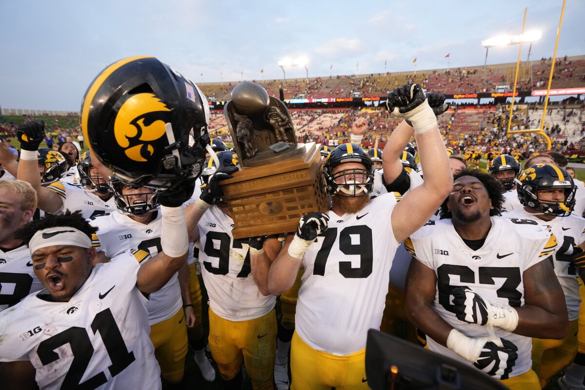 Iowa players hoist the Cy-Hawk Trophy and rejoice in their 27-17 win over Iowa State on Sept. 11, 2021.